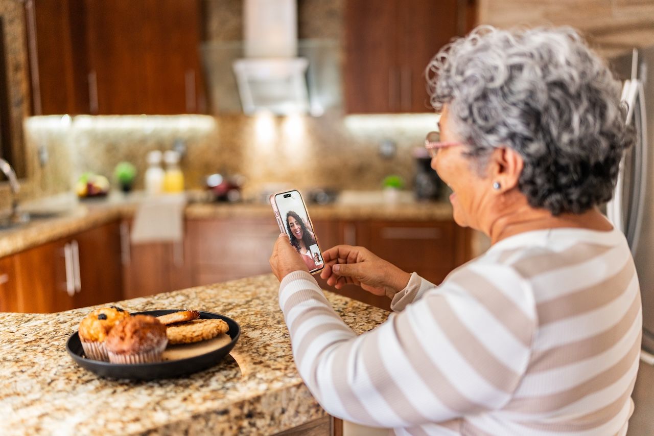 older-adult-woman-video-calling-daughter-during-breakfast