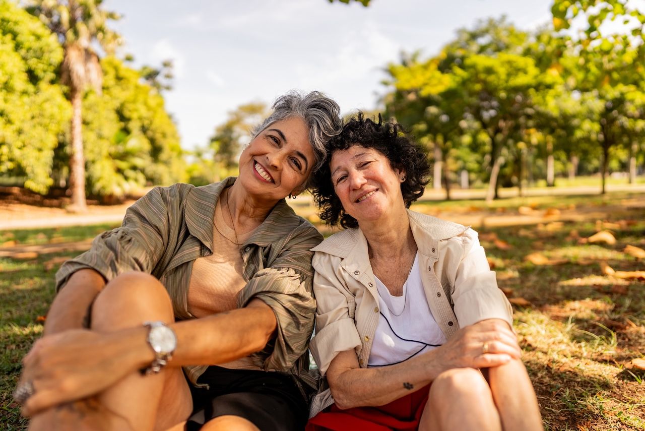 Older adult couple sitting outside together smiling