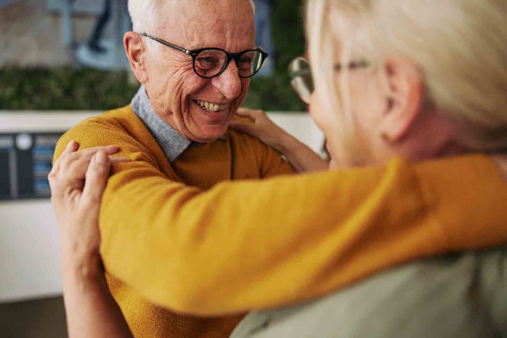 Older man hugging older woman smiling