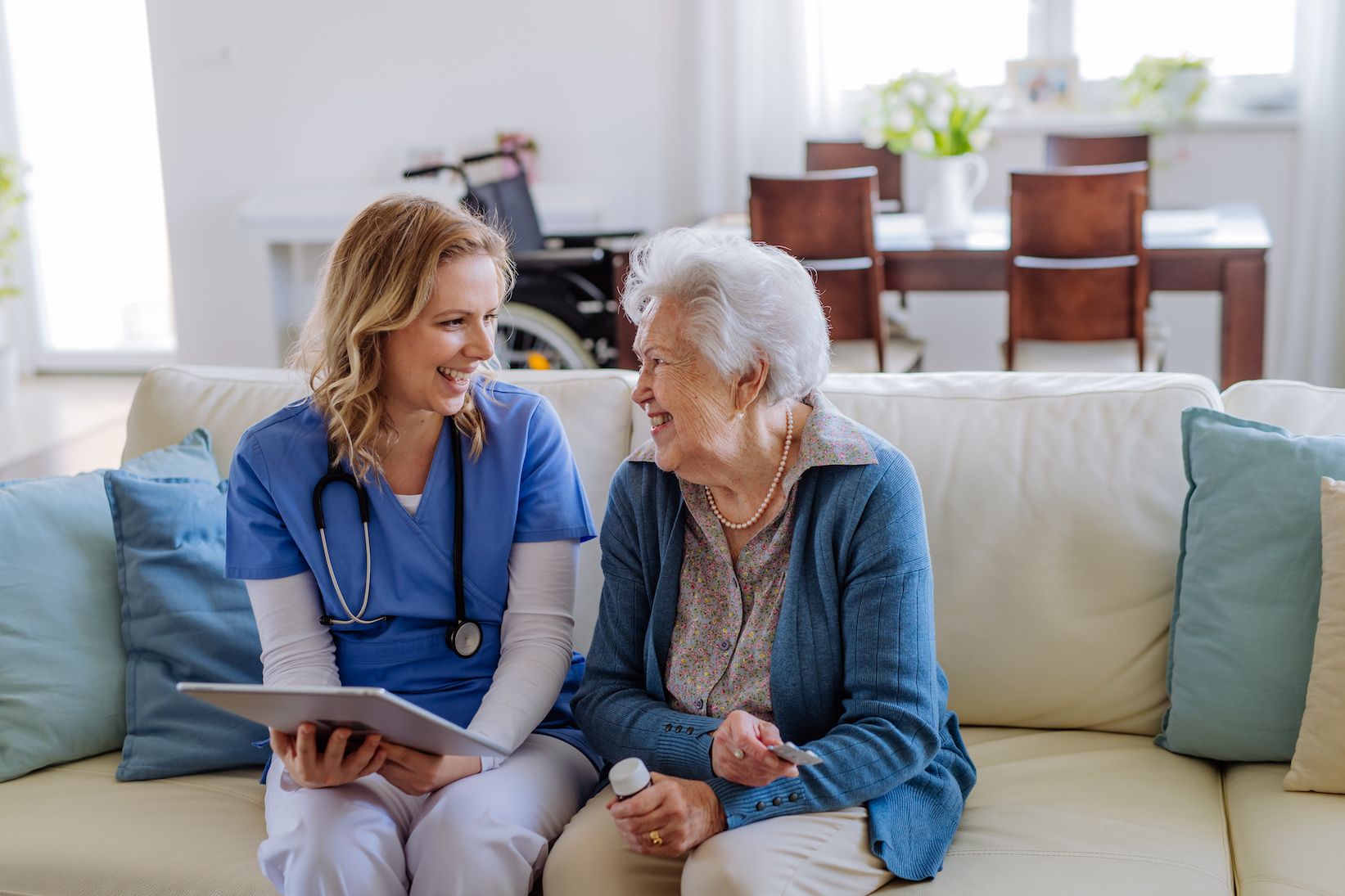 caregiver and older adult laughing on couch