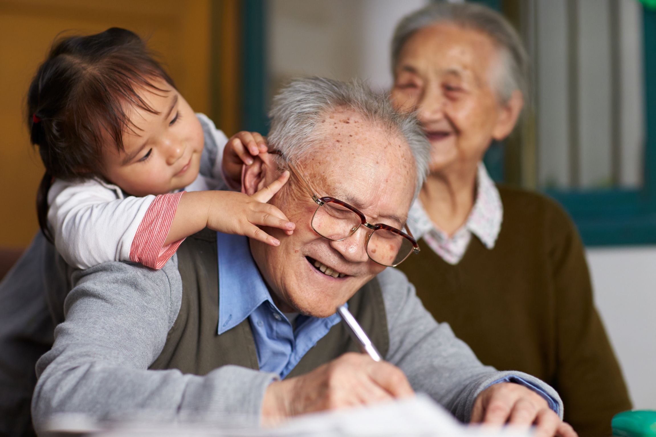 Older Man Writing with Kid and Older Woman