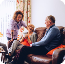 Caregiver and older couple on couch