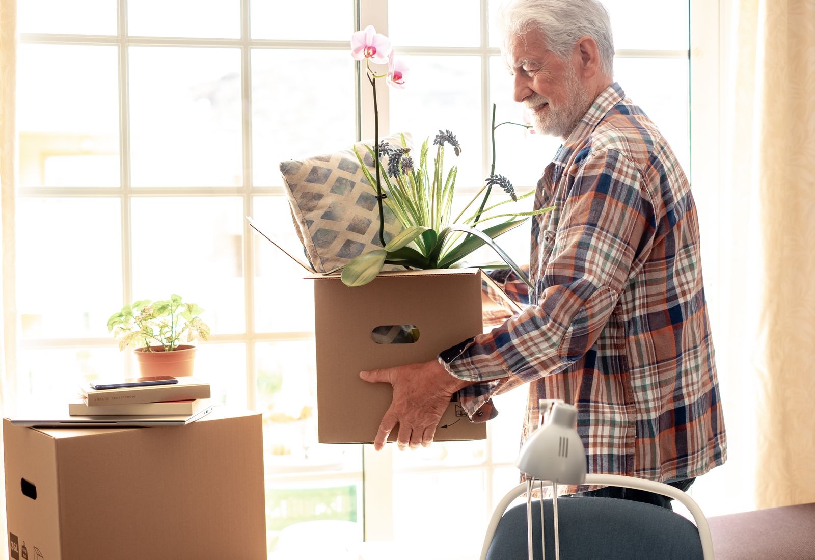 older-adult-moving-a-box-with-a-plant