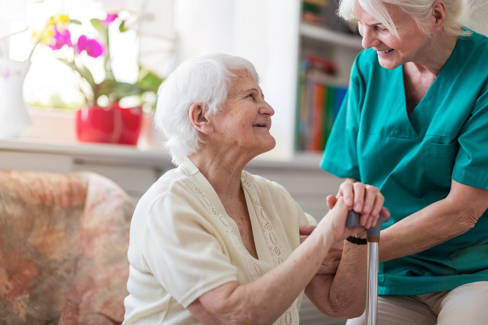 older adult and caregiver smiling at each other