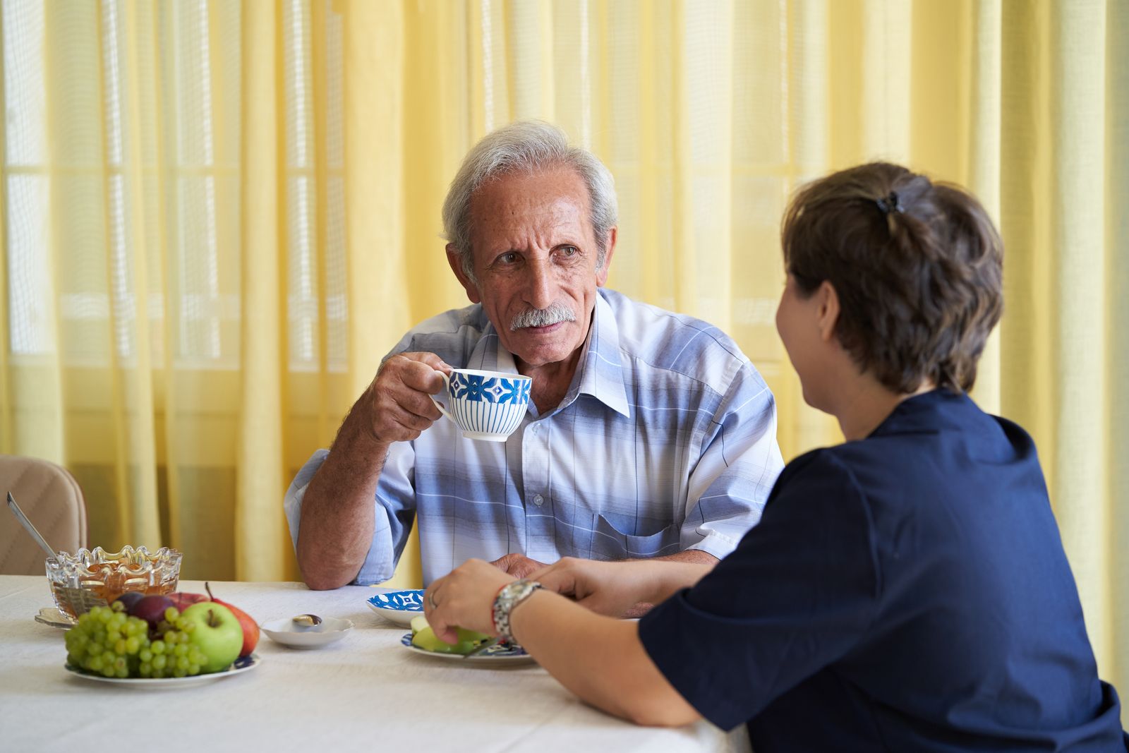 older-adult-at-table-with-caregiver