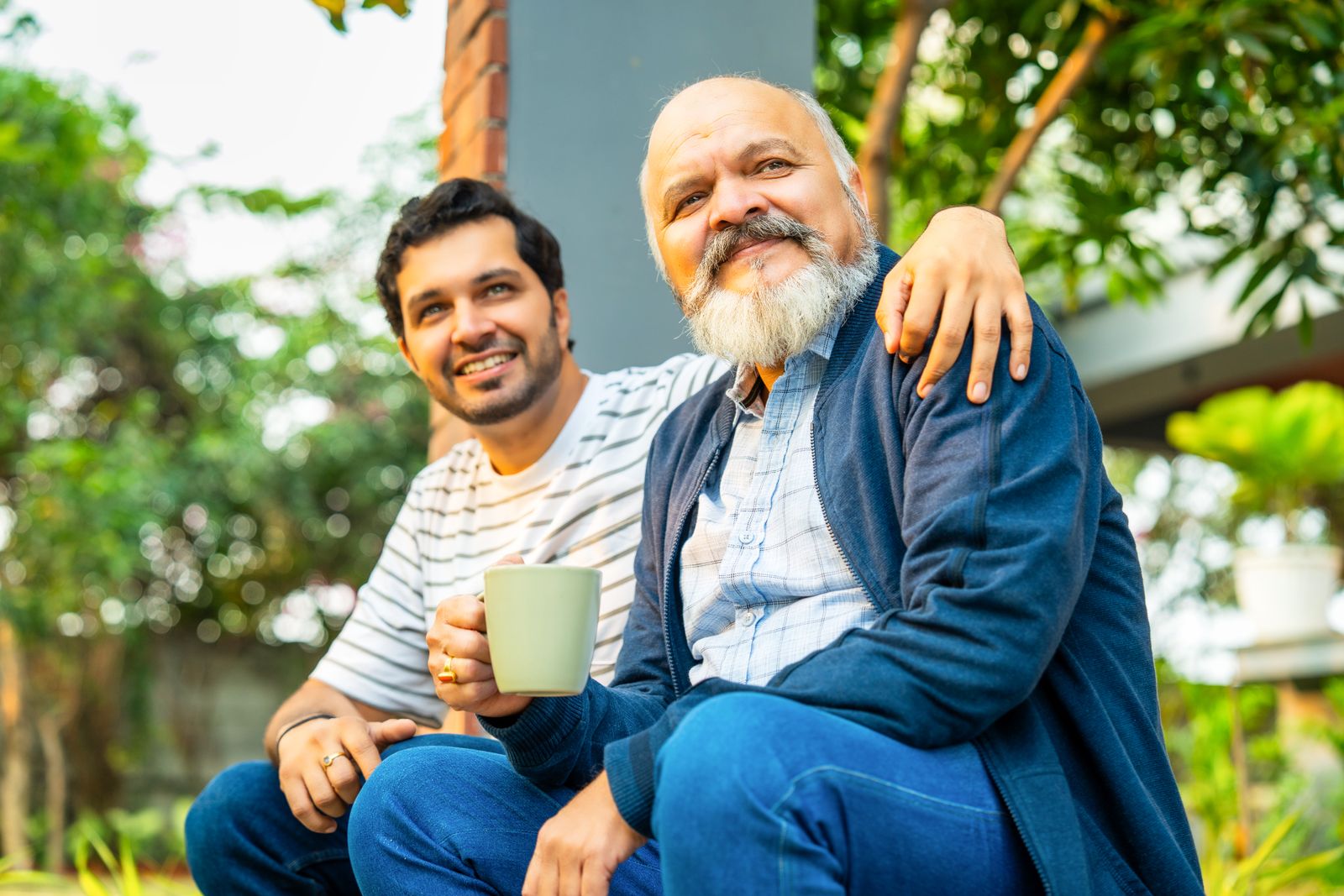 Adult-child-sitting-with-older-adult-outside