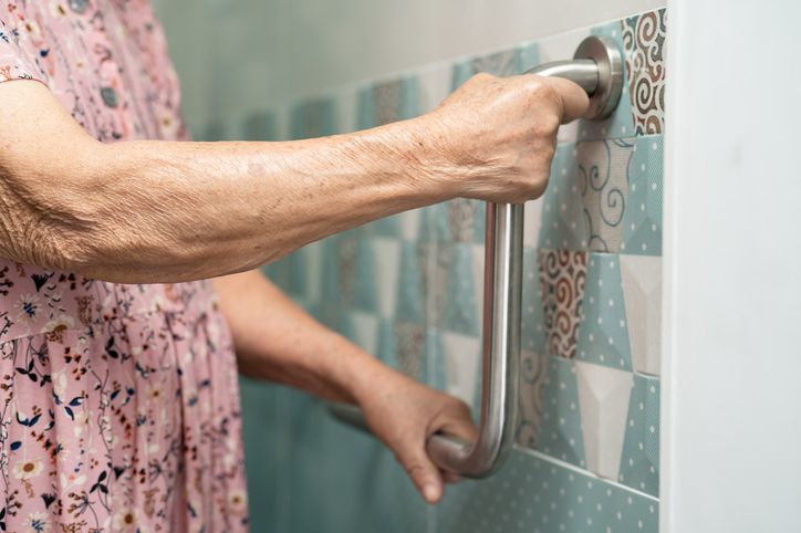 older woman grabbing a show handle