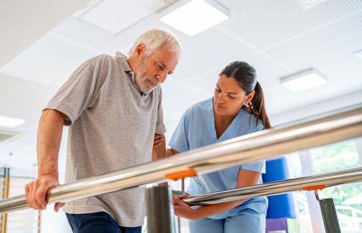 Older adult man doing physical therapy with aide