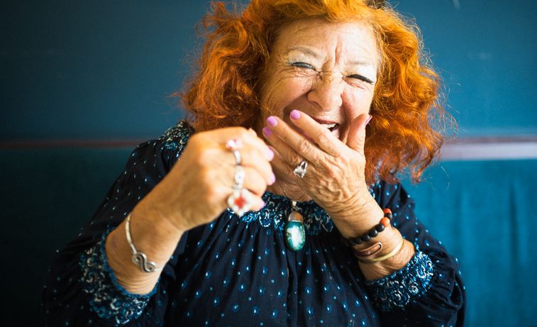 older woman covering her mouth while laughing