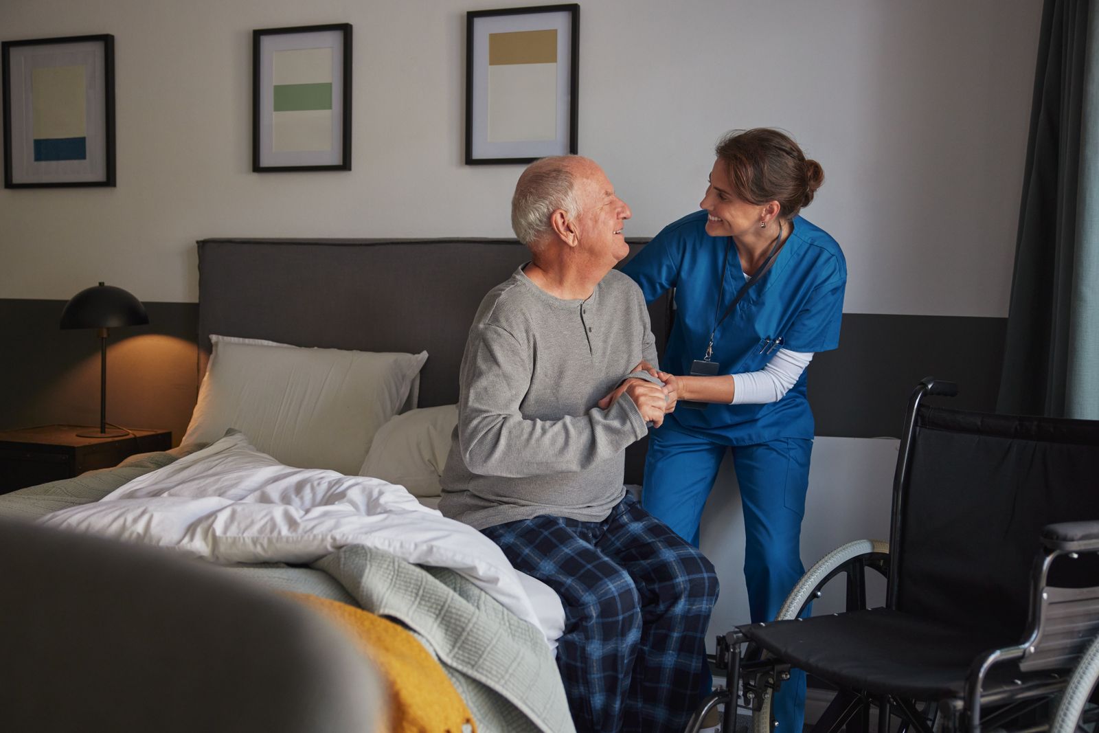 caregiver-helping-older-adult-out-of-bed