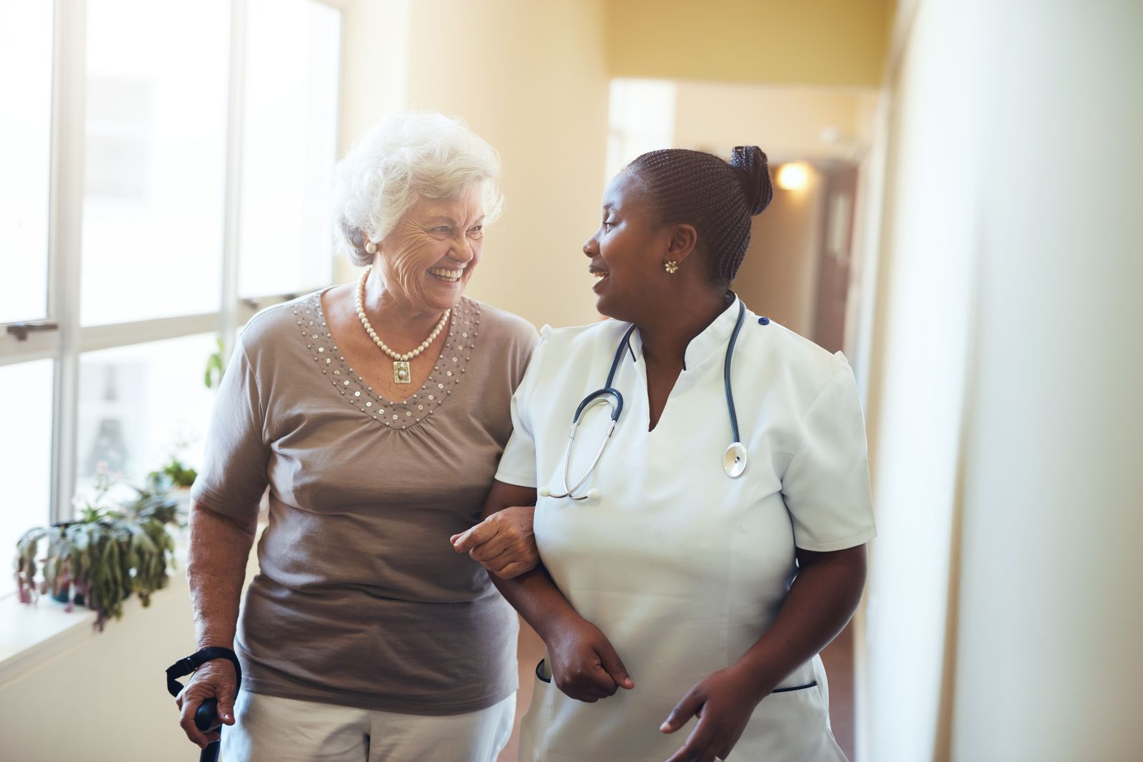 older woman with nurse walking